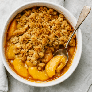 Freshly baked peach cobbler crumble in a rustic pie dish